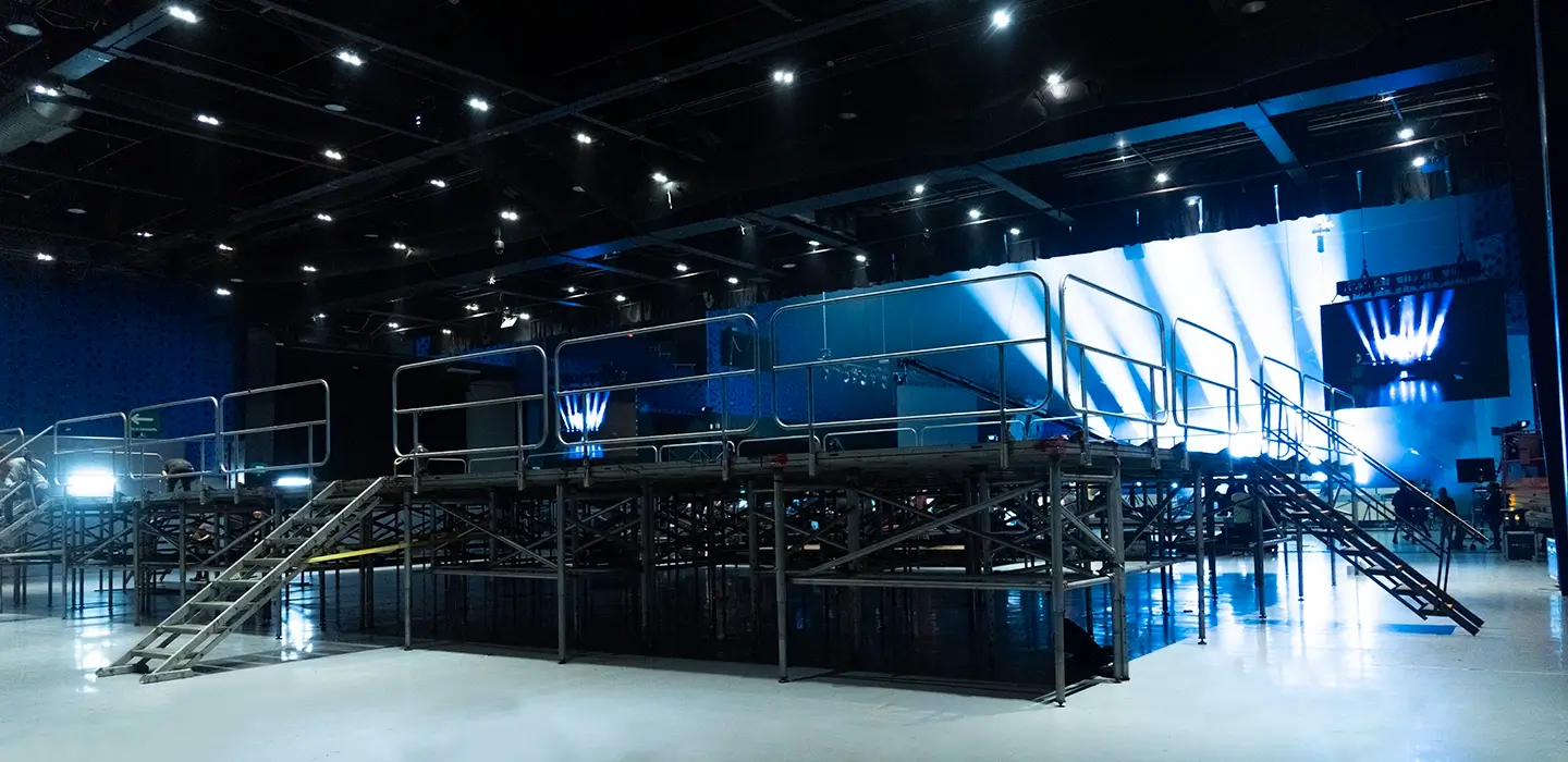 Estructura escalonada construida con sistema de andamios de acero galvanizado tipo Layher y plataformas de asiento en madera, montada sobre terreno rústico nivelado.