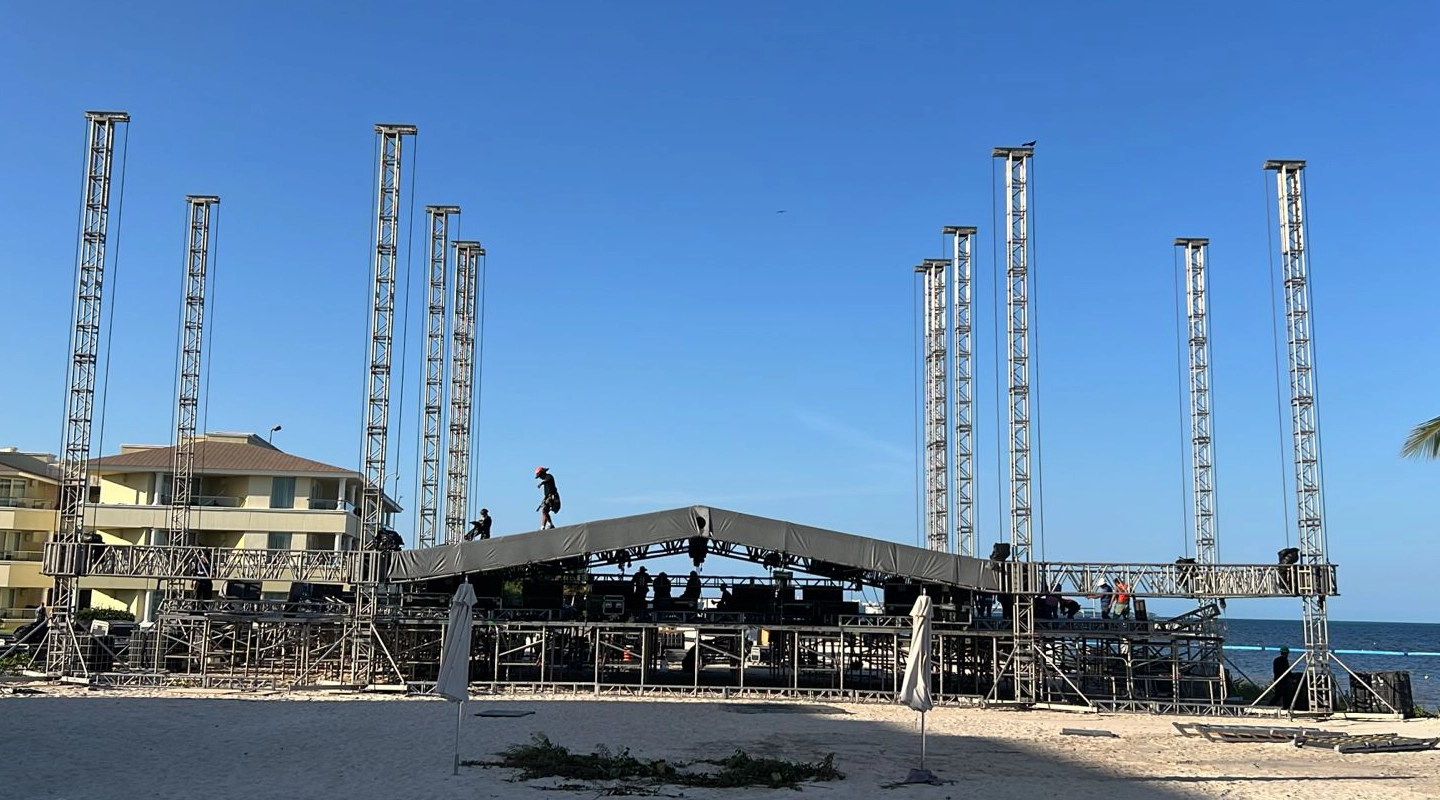 Estructura escalonada construida con sistema de andamios de acero galvanizado tipo Layher y plataformas de asiento en madera, montada sobre terreno rústico nivelado.